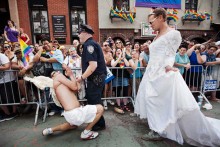 A couple wearing sailor and nurse outfits kiss during the annual Pride Parade in a homage to the famous picture from Times Square in 1945 that symbolizes the end of World War II.